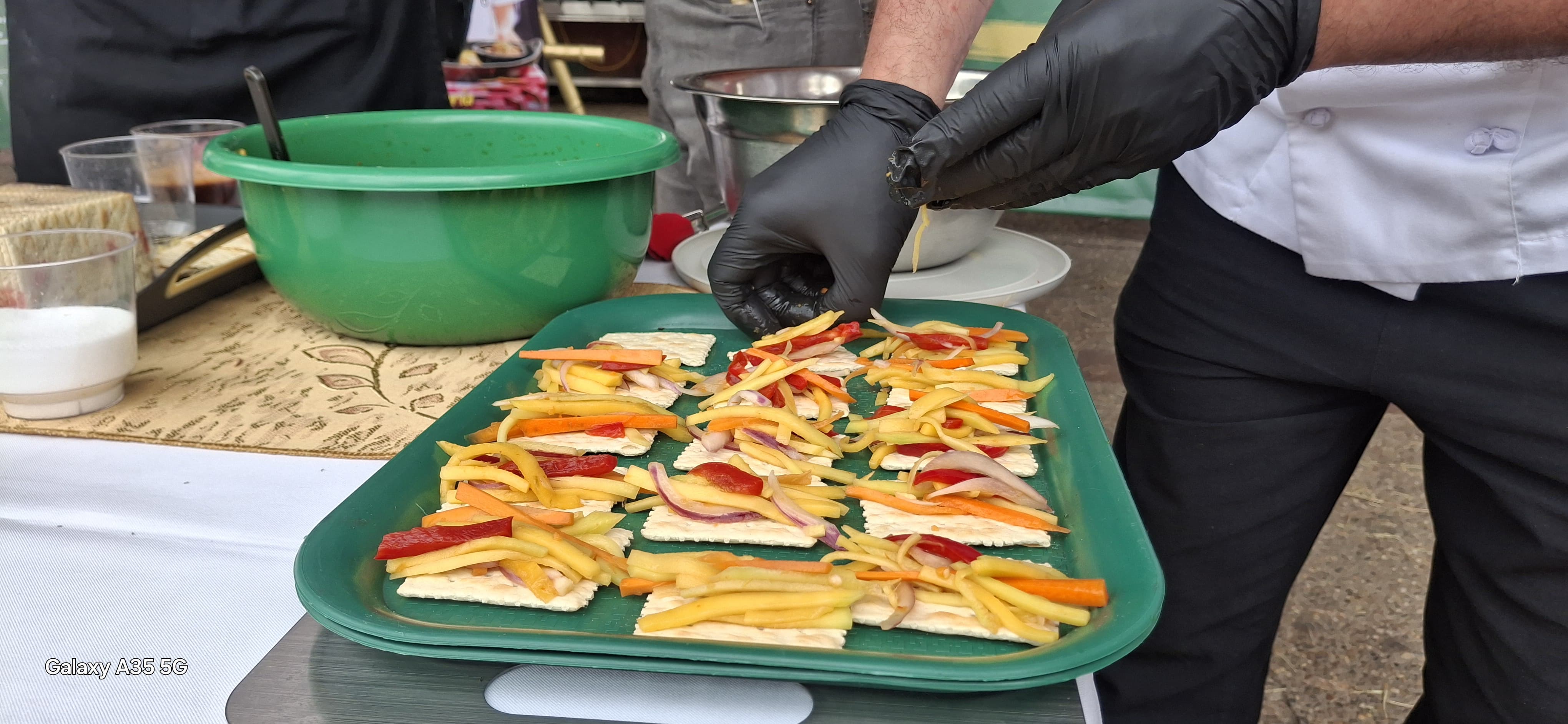 Chef emplatando bocados gourmet con guantes negros