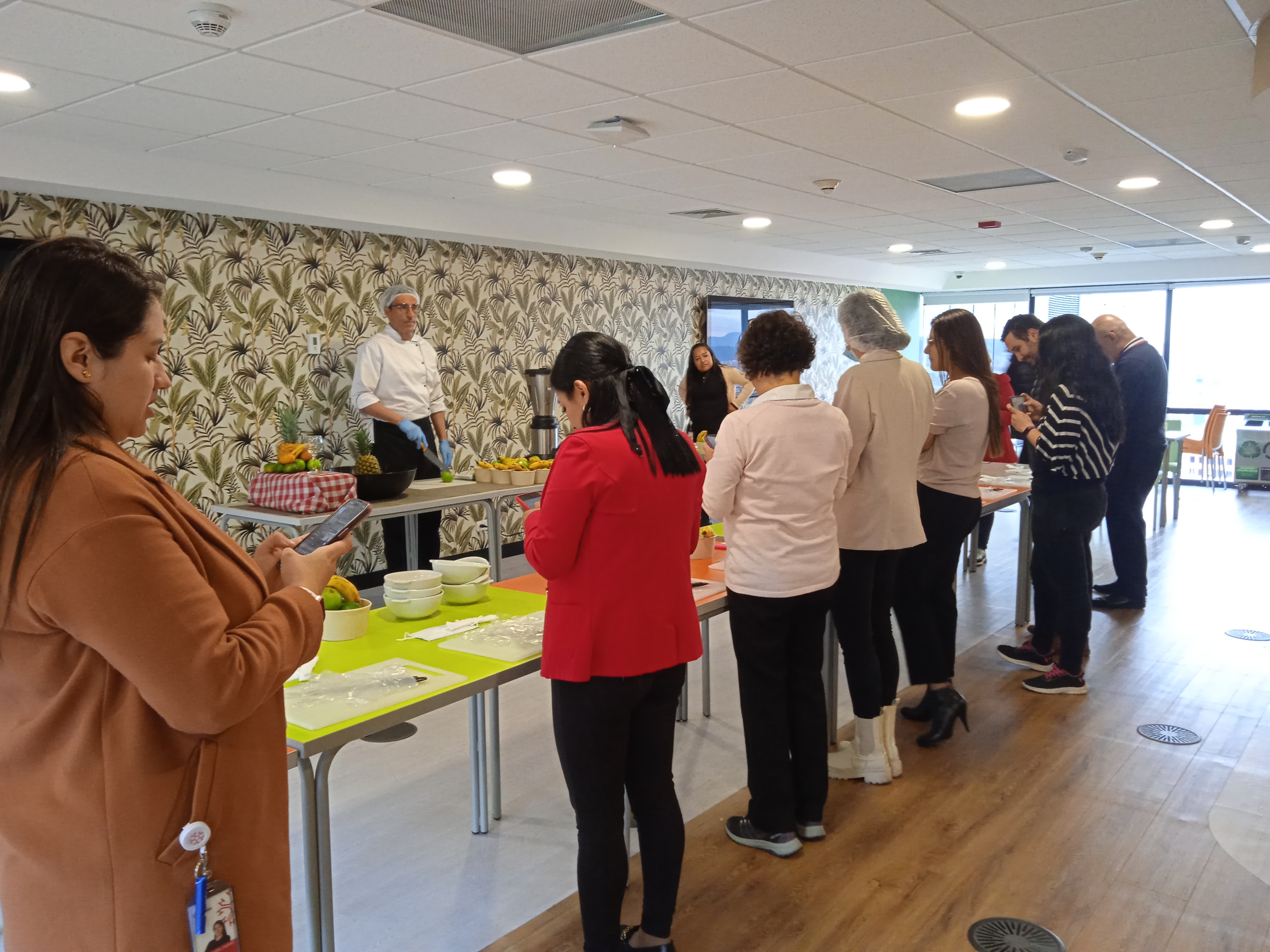 Taller práctico en sala corporativa con estaciones de trabajo individuales
